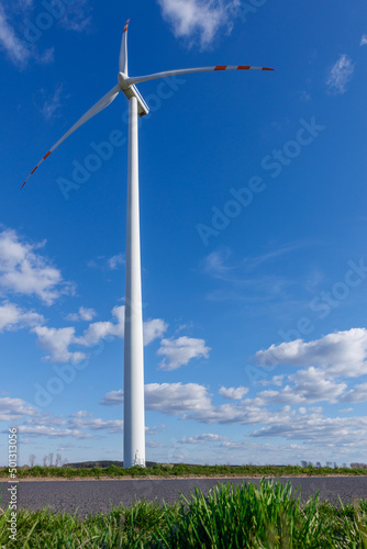 Widok z dołu na turbinę wiatrową na polu. Koncepcja źródeł odnawialnych i dbanie o środowisko.
