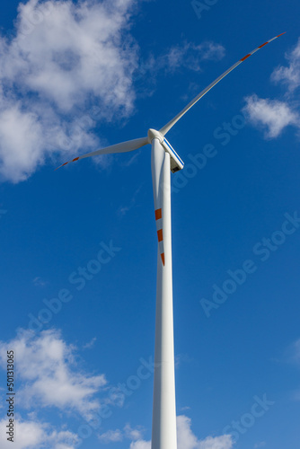 Turbina wiatrowa jako ekologiczna alternatywa źródeł energii. Turbina widoczna na błękitnym niebie. 