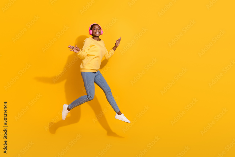 Full length body size view of attractive trendy cheerful girl jumping listening pop copy space isolated over bright yellow color background