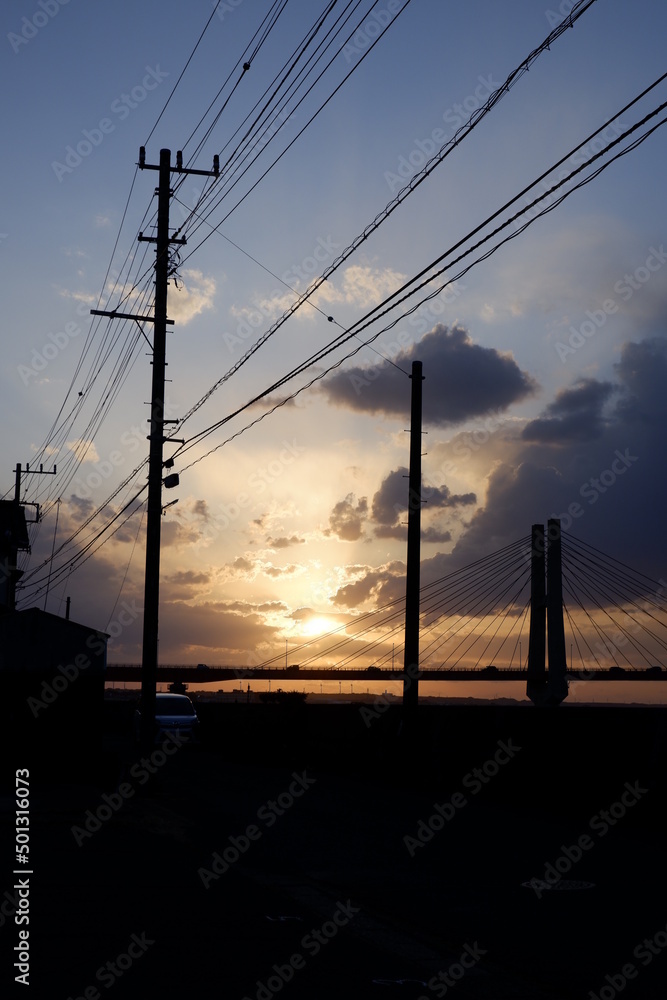power lines with sunset and bridge