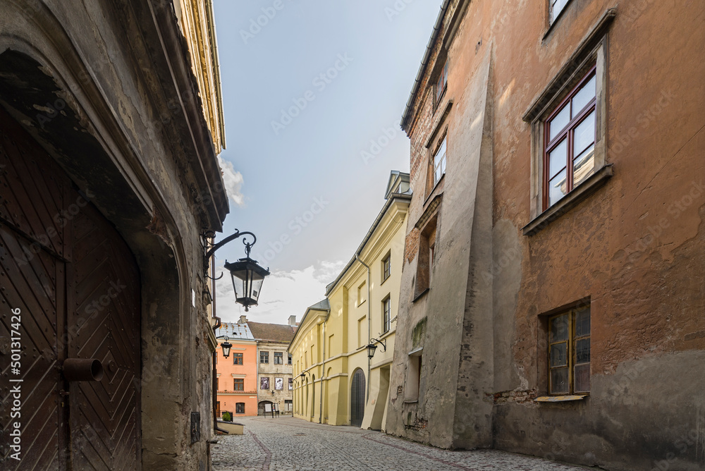 Klimatyczna uliczka na Starym Mieście w Lublinie. Stare i nowe kamienice. Wisząca latarnia na ścianie