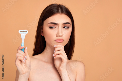 attractive girl holding in hand razor shaver blade i photo