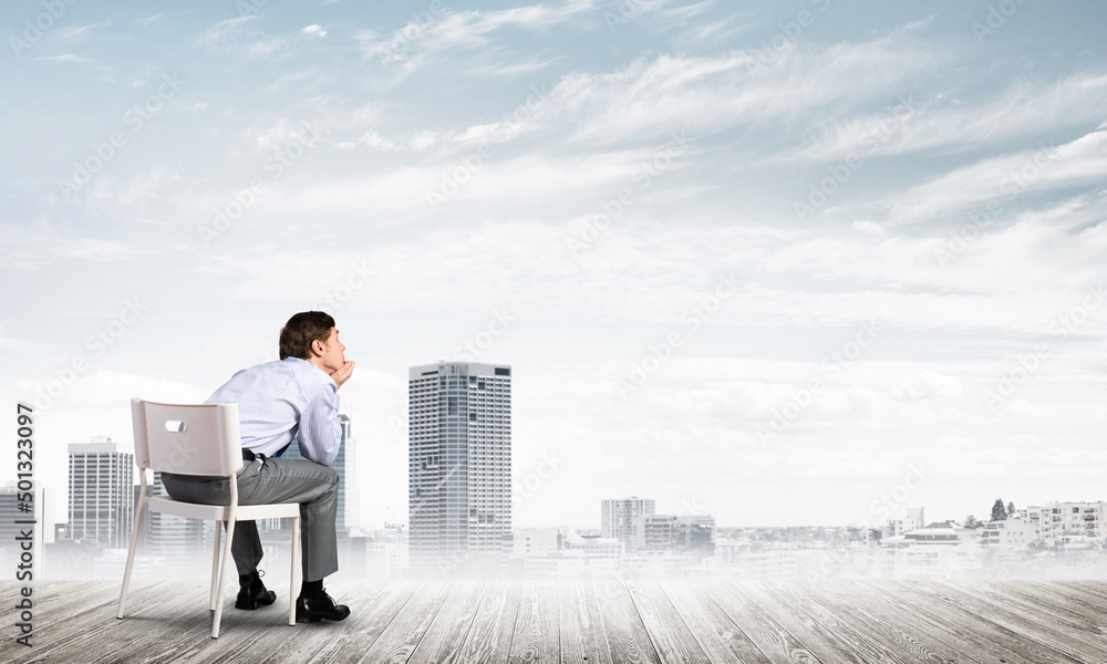 Young businessman sitting on an office chair Young businessman sitting on an office chair