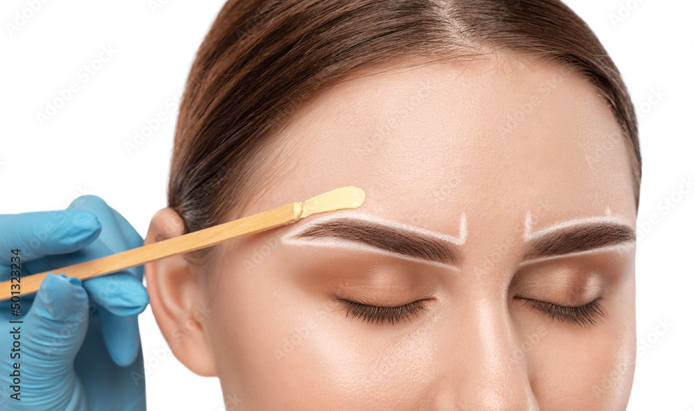Makeup artist does facial hair removal procedure. Beautiful girl with blue eyes having Permanent Make-up on her Eyebrows. Professional makeup. Makeup artist does facial hair removal procedure. Beautiful girl with blue eyes having Permanent Make-up on her Eyebrows. Professional makeup.