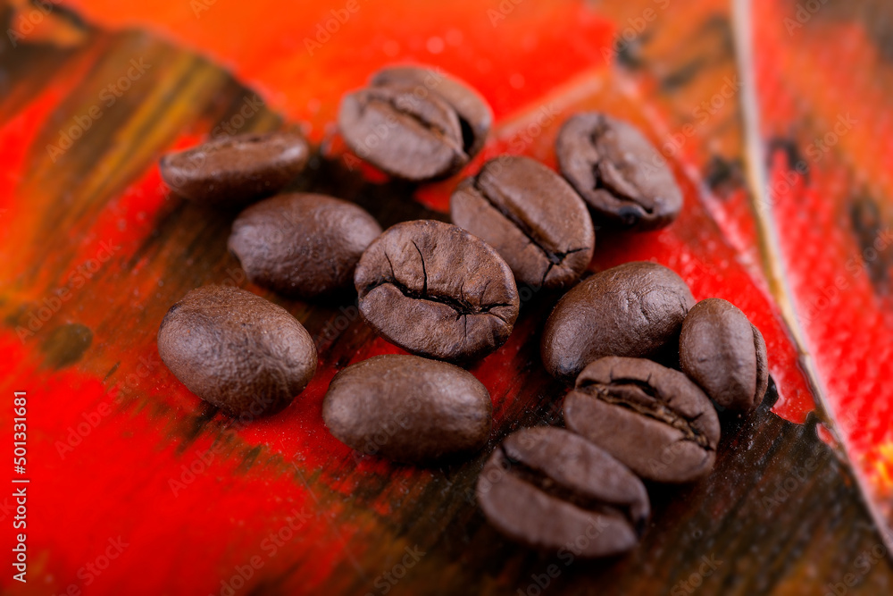 Kaffeebohnen auf rotem Untergrund in Nahaufnahme Kaffeebohnen auf rotem Untergrund in Nahaufnahme