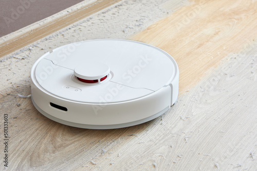 Robot vacuum cleaner cleans the dirty dusty floor of the apartment at a certain time