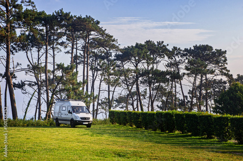 Van on the grass parking lot close to the beach. Campervan parking.