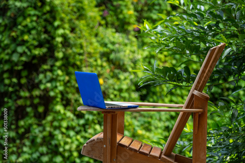 A laptop on a adirondack chair in a rainforest lodge, digital nomad concept, Chiriqui province, Panama, Central America photo