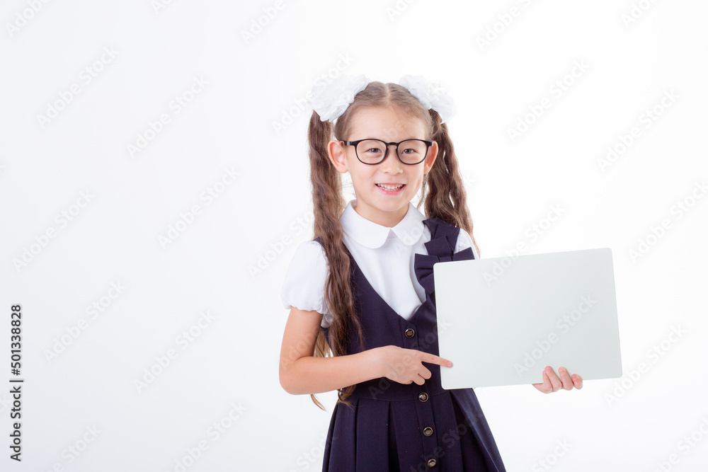 cute little schoolgirl girl in school uniform holding a white sheet of paper isolated on a white background cute little schoolgirl girl in school uniform holding a white sheet of paper isolated on a white background