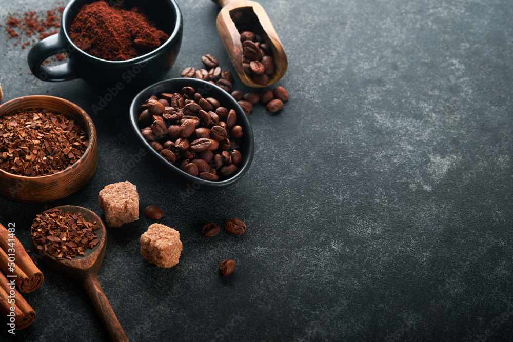 Coffee beans background. Roasted Coffee concept with differents types of coffee, beans and cinnamon sticks on dark black stone background. Top view. Coffee concept. Mock up.