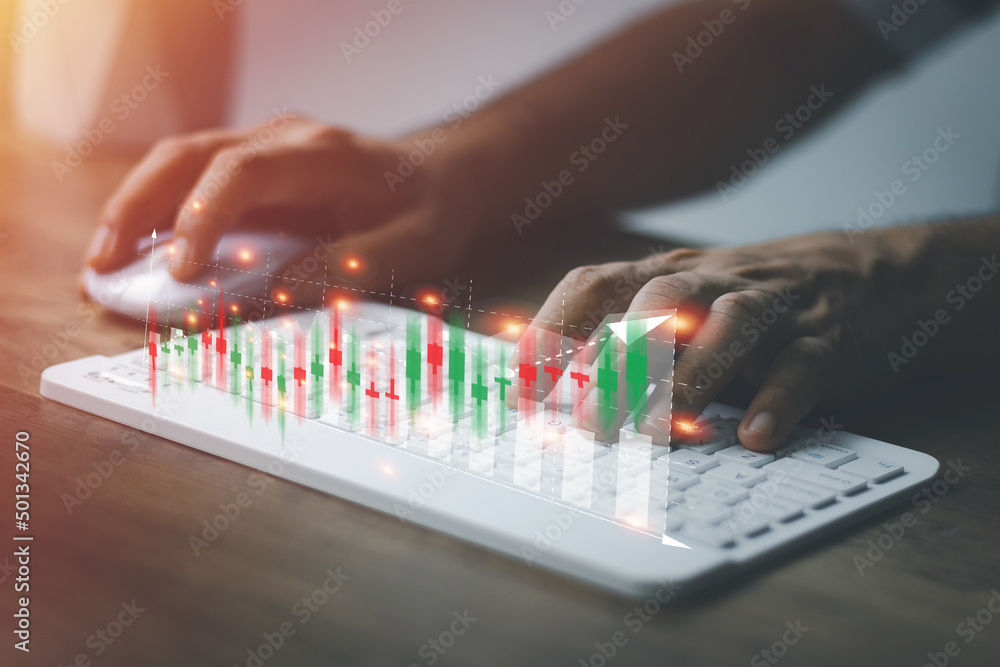 Fototapeta premium financial and investment technology concept,man's hand using computer to analyze graphs and charts of stock market digital assets gold and oil to be in line with the volatility of the world economy