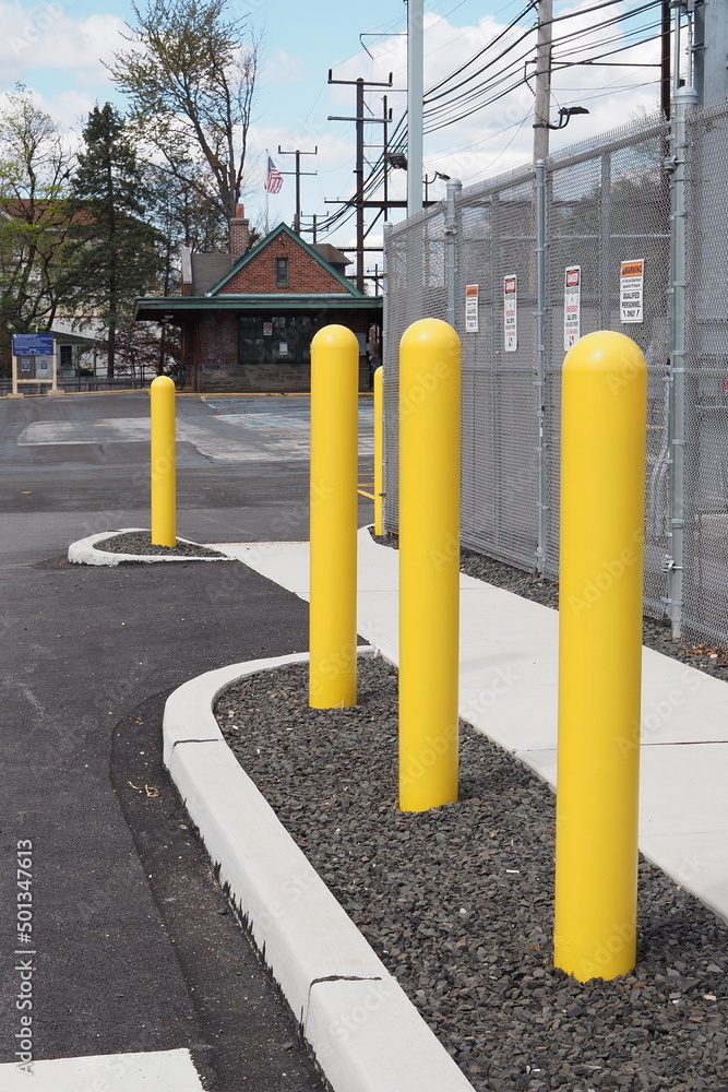 The yellow safety poles prevent cars from driving into the electrical wiring. The yellow safety poles prevent cars from driving into the electrical wiring.