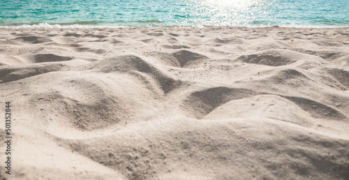 Beach sand sea water summer background. Sand beach desert texture. White foam wave sandy seashore