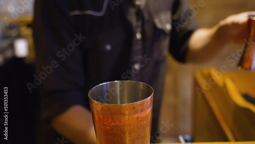 Bartender dumps shot into shaker, pours measured jigger, slow motion 4K photo