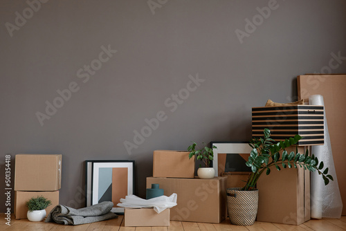 Horizontal no people shot of unpacked boxes and various stuff placed in loft room against gray wall