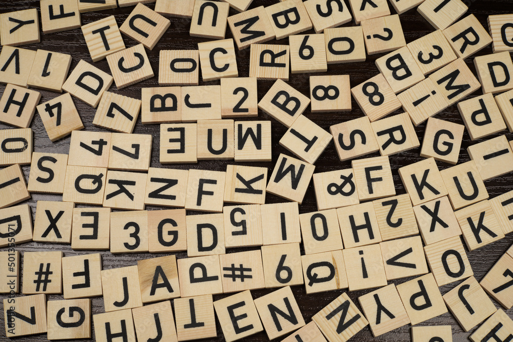 Wooden tiles with latin alphabet letters and characters on a table (brown background) Wooden tiles with latin alphabet letters and characters on a table (brown background)