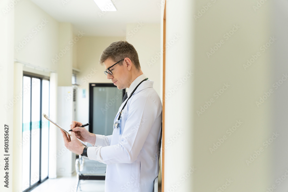 Fototapeta premium A handsome male doctor is leaning towards the hospital.