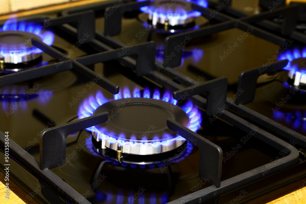 Four lit burners on a gas hob Four lit burners on a gas hob