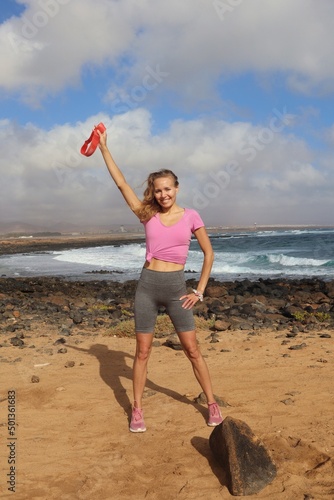 Uśmiechnięta kobieta w stroju sportowym na plaży