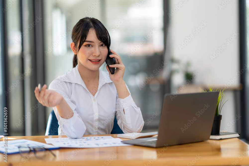 business woman using, touching on mobile smart phone screen while working on laptop computer on desk at home office, E-business, internet technology concept business woman using, touching on mobile smart phone screen while working on laptop computer on desk at home office, E-business, internet technology concept