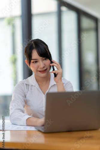 business woman using, touching on mobile smart phone screen while working on laptop computer on desk at home office, E-business, internet technology concept