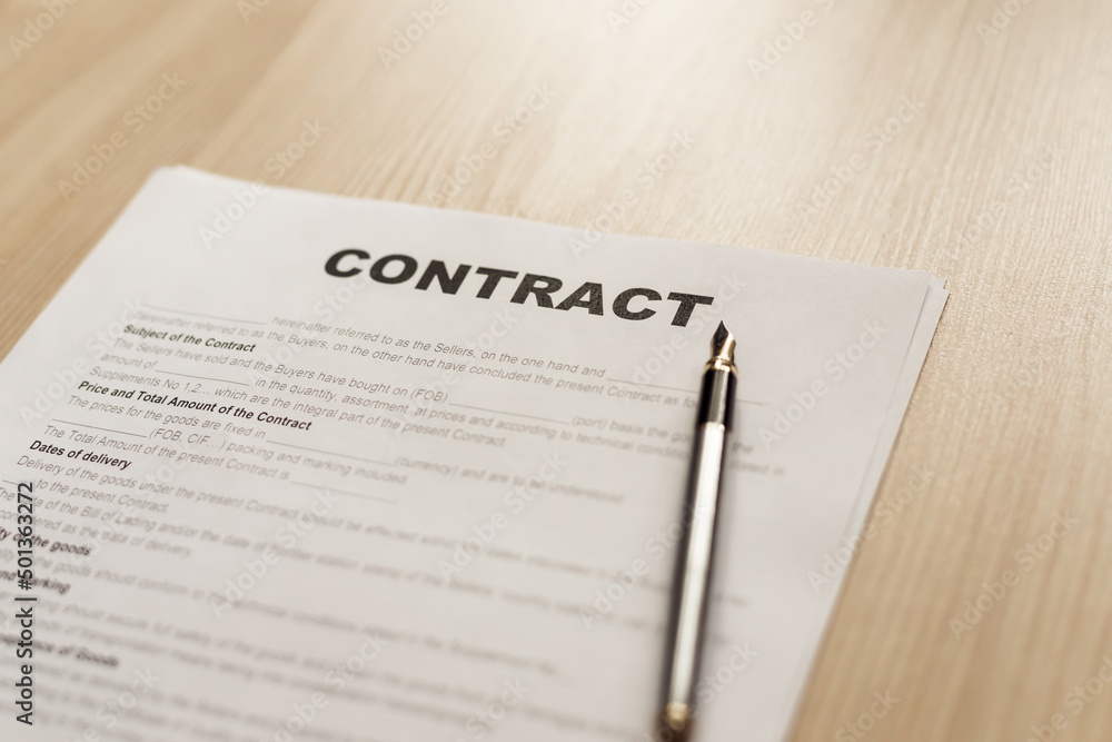 Ink pen and contract papers on wooden desk Ink pen and contract papers on wooden desk