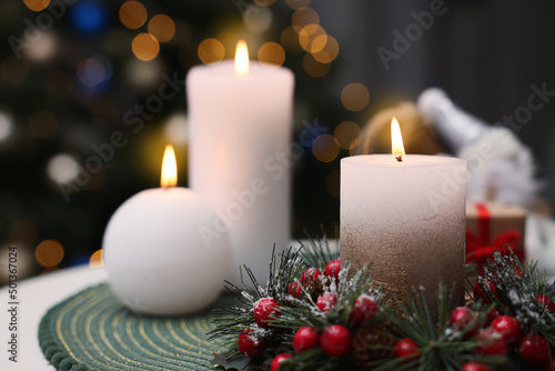 Beautiful burning candles and Christmas decor on white table indoors