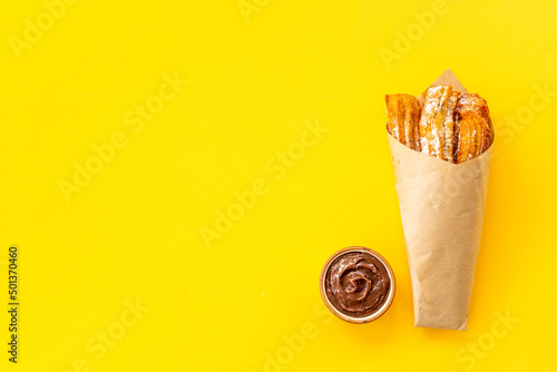 Street food dessert churros in paper bag with sugar