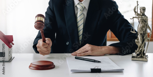 Lawyer or judge holding Hammer prepares to judge the case with justice, and litigation, scales of justice, law hammer, Legal consulting services, Concept of litigation, and legal services.