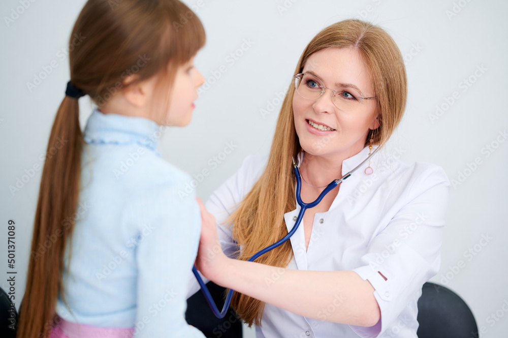 Cheerful female doctor checking patient little girl by stethoscope in hospital Cheerful female doctor checking patient little girl by stethoscope in hospital