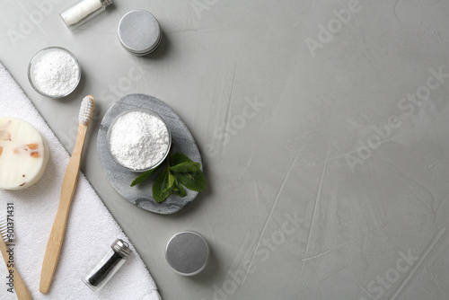 Flat lay composition with tooth powder and mint on grey table, space for text