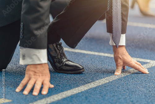 Fototapeta Naklejka Na Ścianę i Meble -  Close-up photo of businessman standing on race track