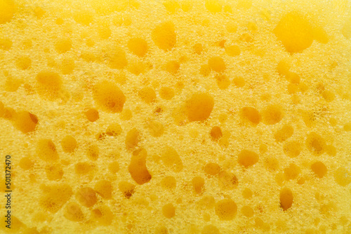 Yellow cleaning sponge as background, top view