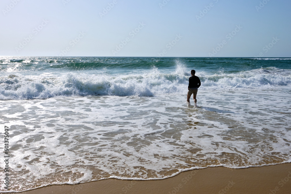 Depressed man looking at the horizon on the beach Depressed man looking at the horizon on the beach