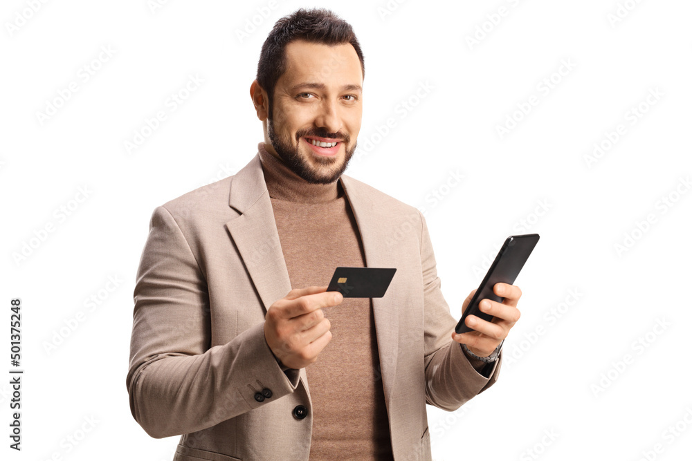Young man with a credit card and a mobile phone looking at camera and smiling Young man with a credit card and a mobile phone looking at camera and smiling