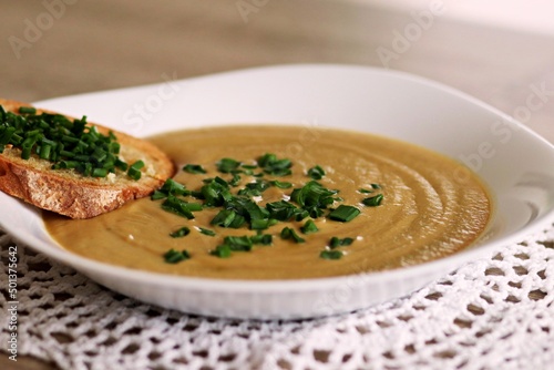 Jarzynowa zupa krem z grzanką na białym talerzu photo