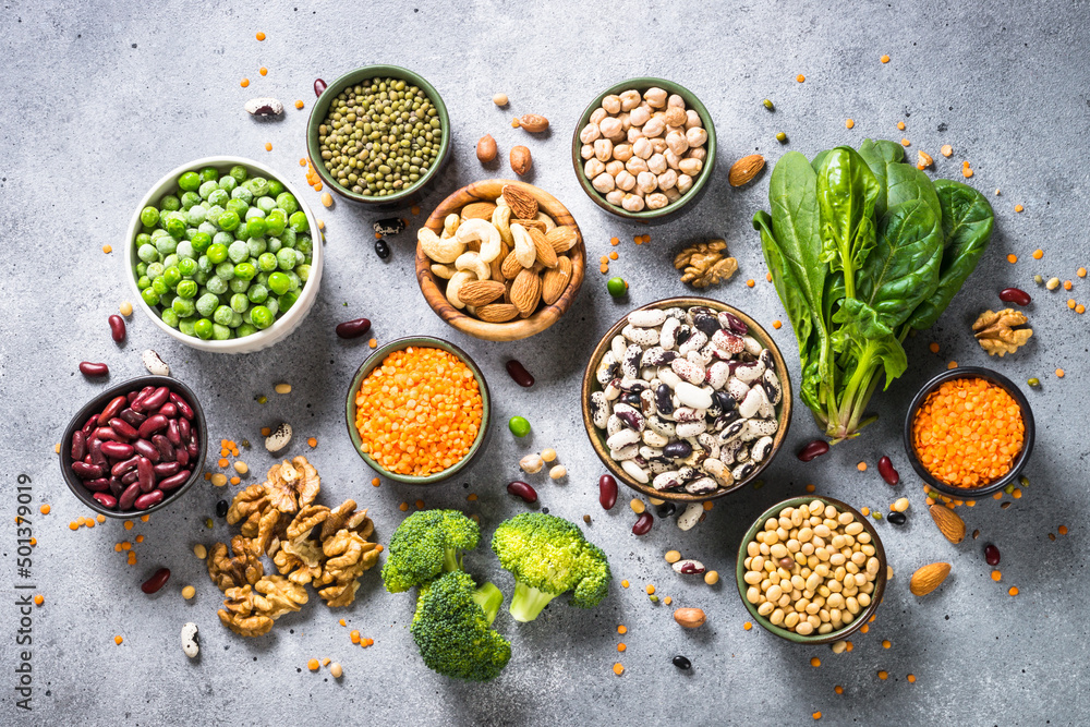 Vegan protein source. Legumes, beans, lentils, nuts, broccoli, spinach and seeds. Plant based food. Top view on gray stone table. Vegan protein source. Legumes, beans, lentils, nuts, broccoli, spinach and seeds. Plant based food. Top view on gray stone table.