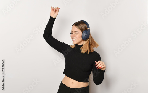 bellissima ragazza che ascolta la musica e balla con le cuffie photo