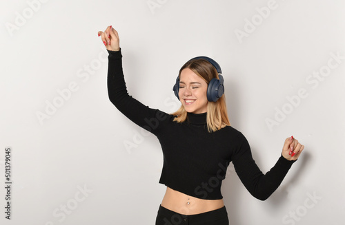 bellissima ragazza che ascolta la musica e balla con le cuffie photo