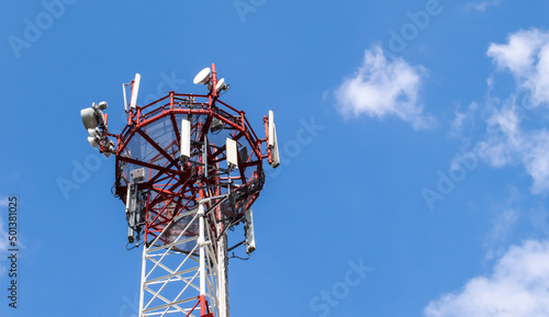 Telecommunication tower of 4G and 5G cellular. Macro Base Station. 5G radio network telecommunication equipment with radio modules and smart antennas mounted on a metal against cloulds sky background.