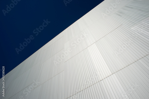 steel cladding on the side of a modern building with a blue sky.