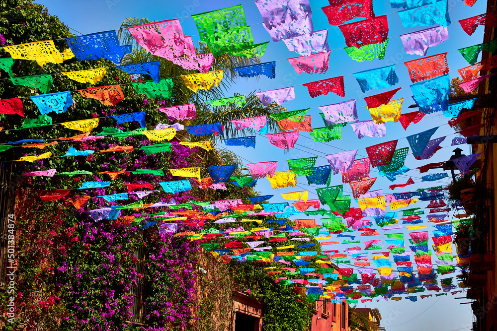 calle colorida con adornos de papel de colores en un día soleado en san miguel de allende guanajuato