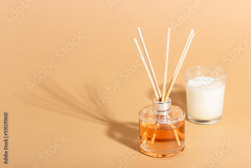 reed diffuser bottle on a beige background. Incense sticks for the home with a floral scent. The concept of eco-friendly fragrance for the home