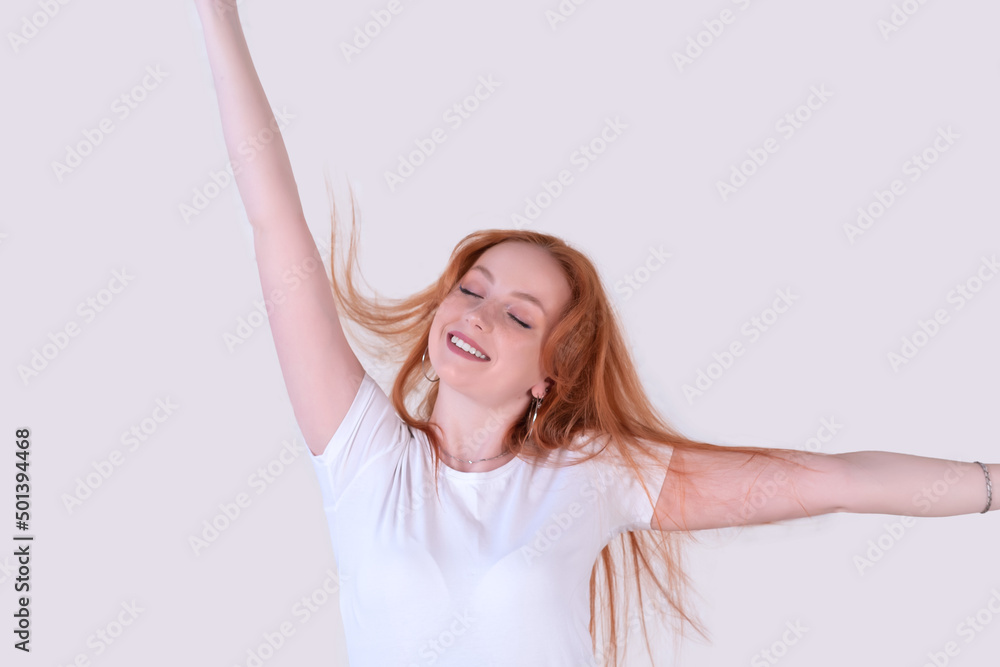 young woman with tousled hair stretches on a light background young woman with tousled hair stretches on a light background