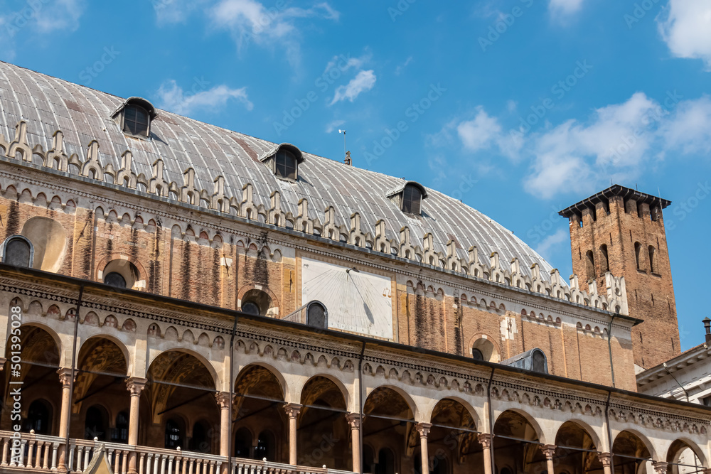 The scenic view from Piazza delle Erbe on the loggia which is the external balcony of Palazzo della Ragione in Padua, Veneto, Italy, Europe. Light beams on beautiful colonnade with column architecture