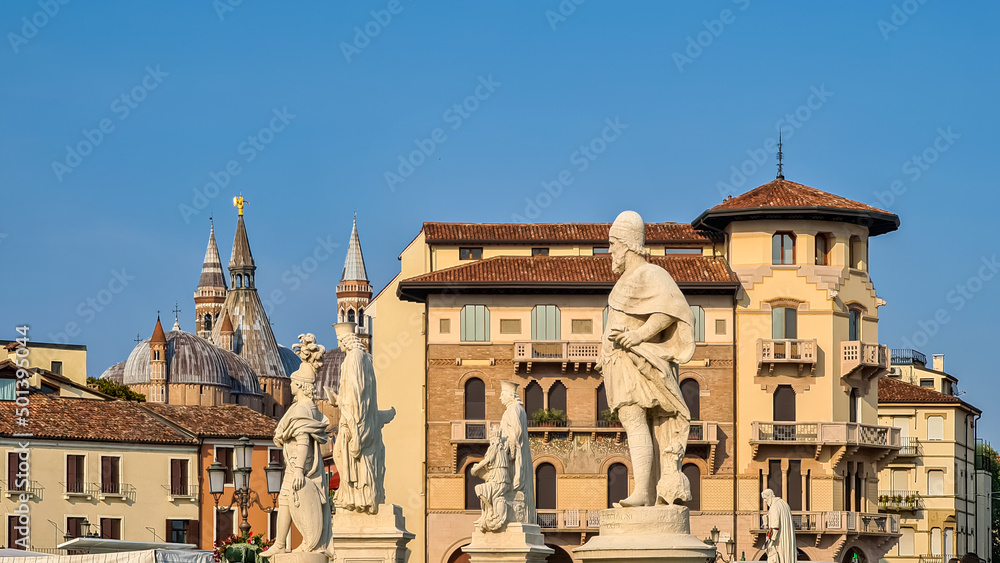 Scenic view on Basilica of Saint Anthony from Prato della Valle, square in the city of Padua, Veneto, Italy, Europe. Green island at center, Isola Memmia surrounded by canal bordered by statues