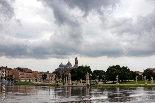 Scenic view after strong rain on Prato della Valle  Abbey of Santa Giustina  square in city of Padua  Veneto  Italy  Europe. Rain storm  black clouds in sky. Isola Memmia surrounded by canal  statues
