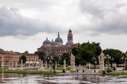 Scenic view after strong rain on Prato della Valle, Abbey of Santa Giustina, square in city of Padua, Veneto, Italy, Europe. Rain storm, black clouds in sky. Isola Memmia surrounded by canal, statues photo
