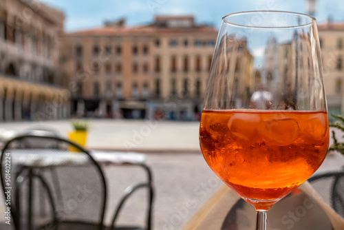 Typical italian alcoholic aperitif (aperitivo) served in a bar on Piazza delle Erbe in Padova, Veneto, Italy, Europe. Aperol Spritz with ice cubes on a summer day. Padua, birth place of Aperol