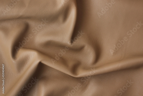 Fotografie a piece of caramel beige artificial leather close-up with Abstract waves and fol